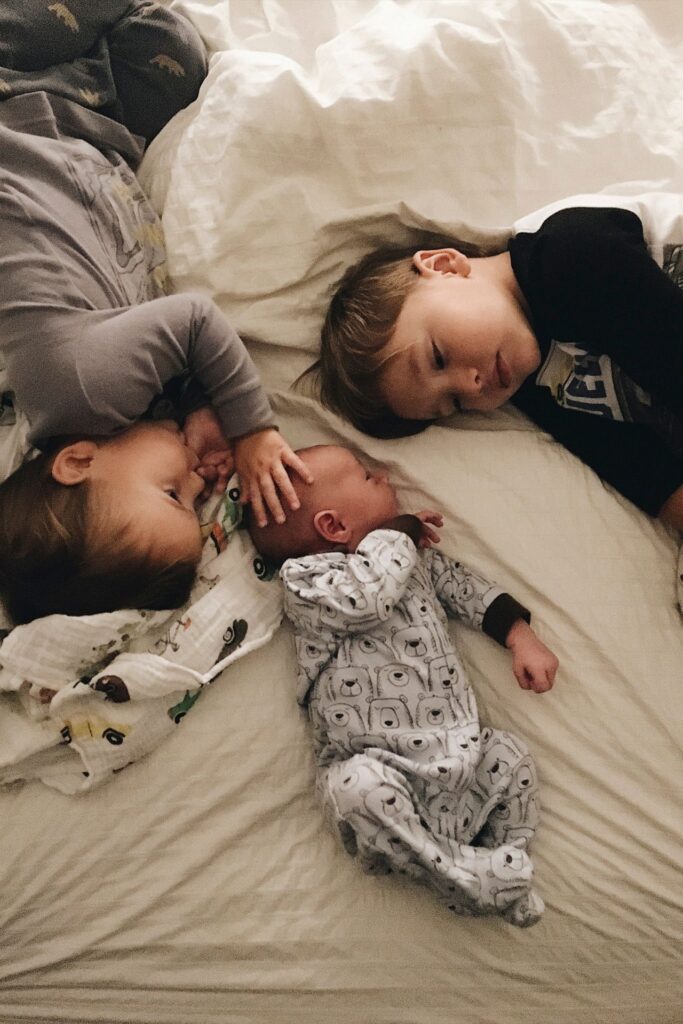 Geschwister liegen im Bett und kuscheln