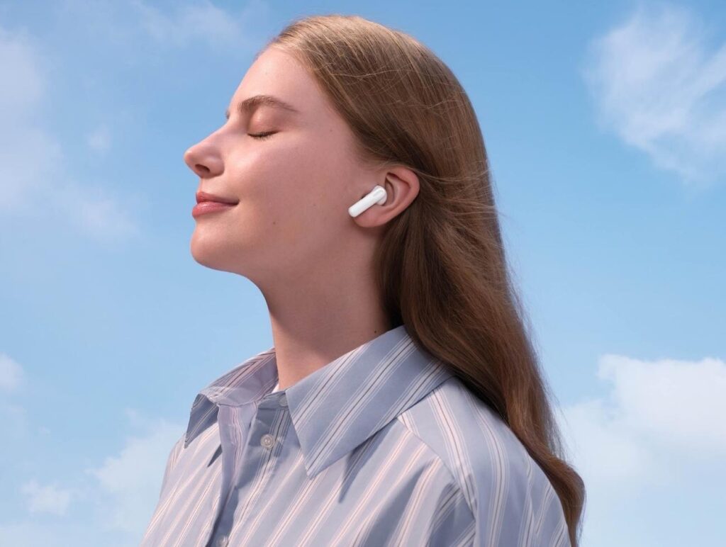 Eine Frau blickt in die Sonne und hört mit den Huawei FreeBuds SE2 Musik.
