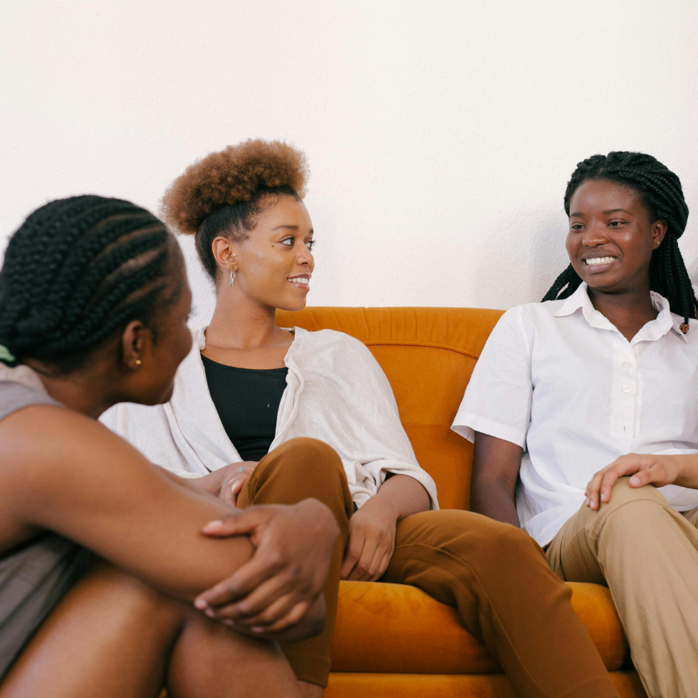 Frauen, die auf einer Couch sitzen und miteinander reden