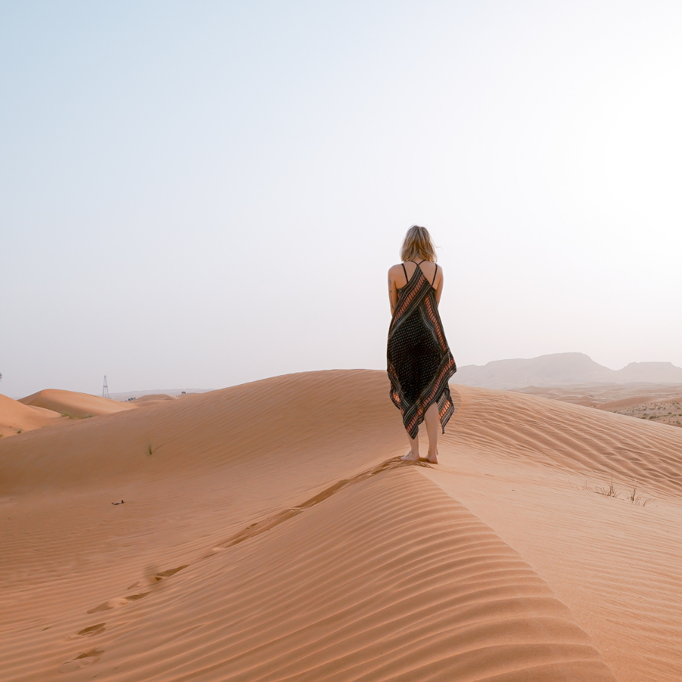 Persönlichkeitsentwicklung: Frau geht entlang einer Sanddüne