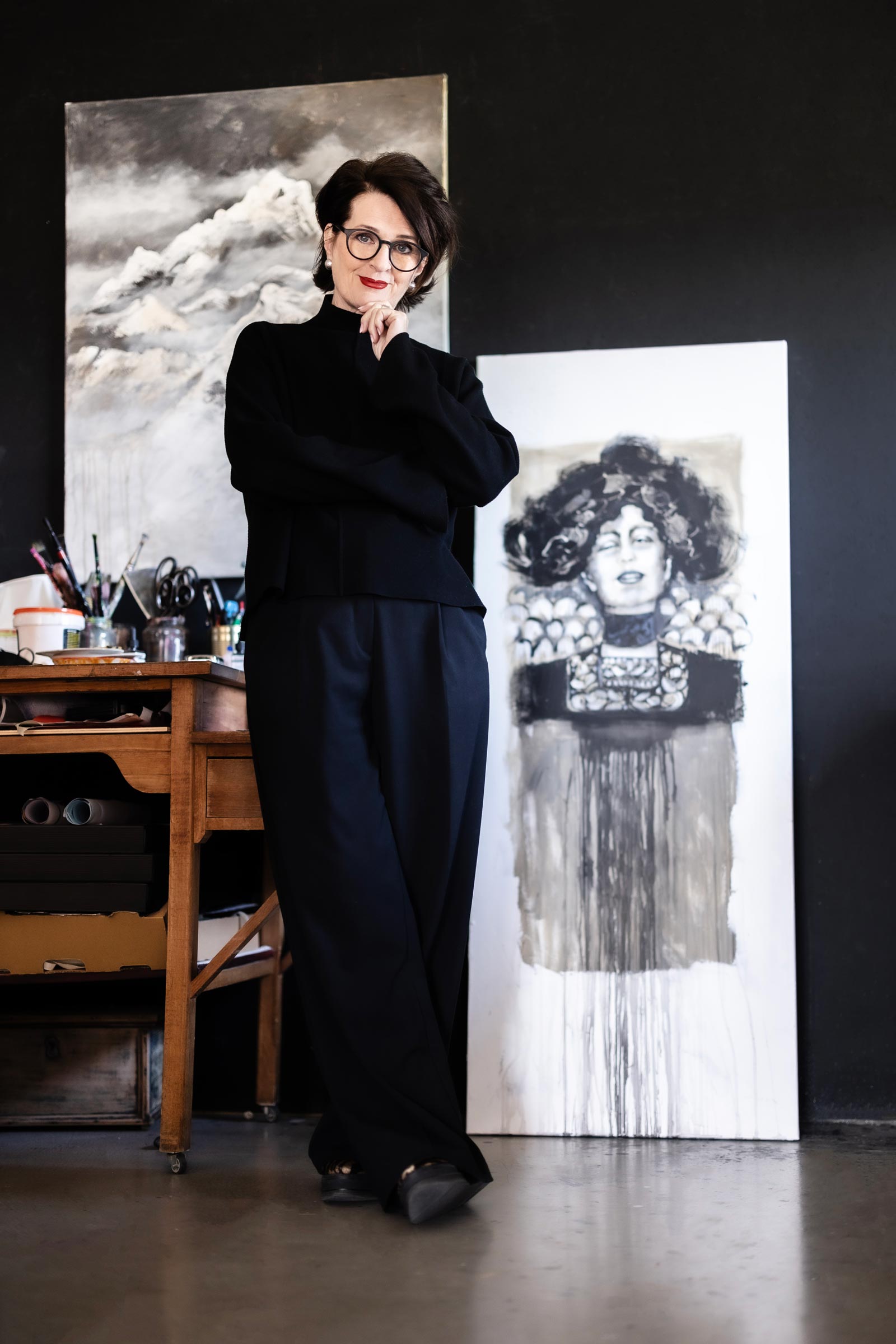 Ulrike Maria Kleber in ihrem Atelier, stehend vor einem ihrer Werke – eine Verbindung von Persönlichkeit und künstlerischer Handschrift.