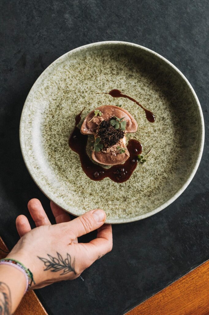 Detailaufnahme eines kunstvoll angerichteten Gourmet-Tellers im Hotel Arlberg – fotografiert mit Fokus auf Textur und Licht.