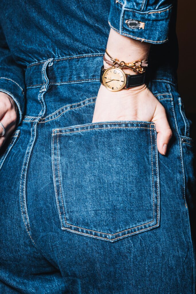 Unkonventionelles Close-up eines Jeans-Outfits mit goldener Armbanduhr – kreative Produktinszenierung für das Label Offfhand.