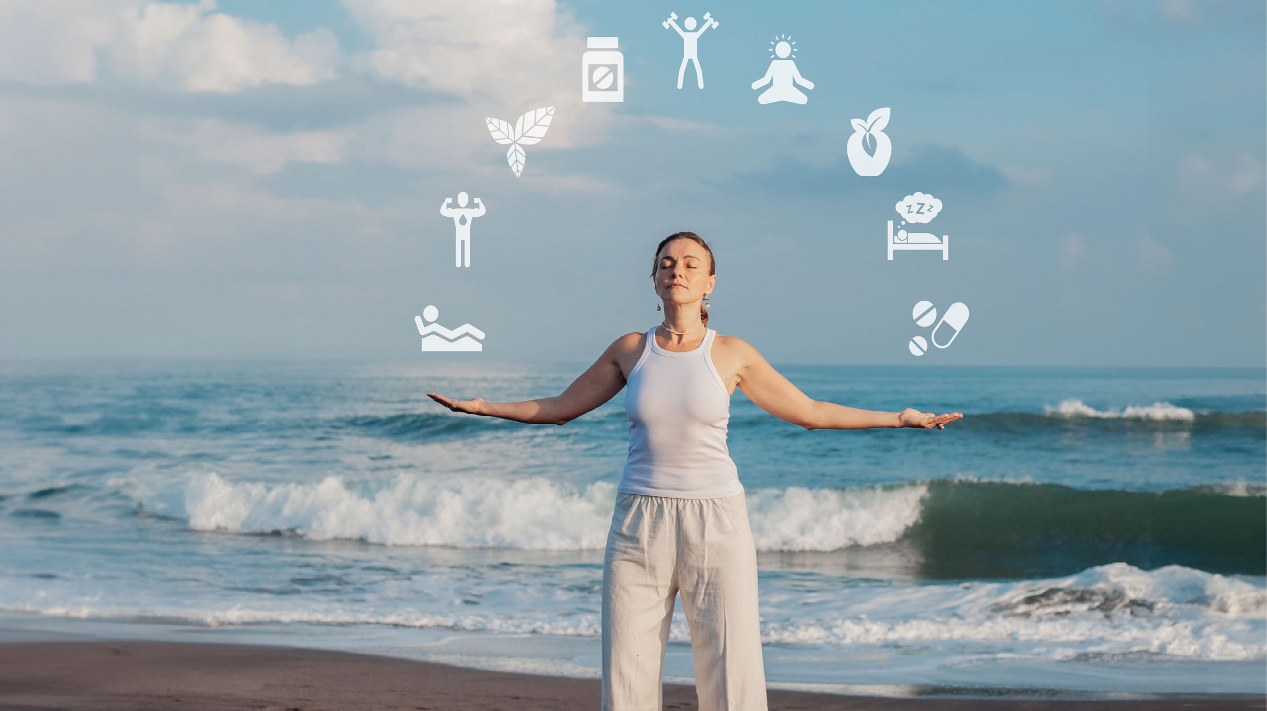 Longevity: Frau steht meditierend am Strand mit Meer im Hintergrund.