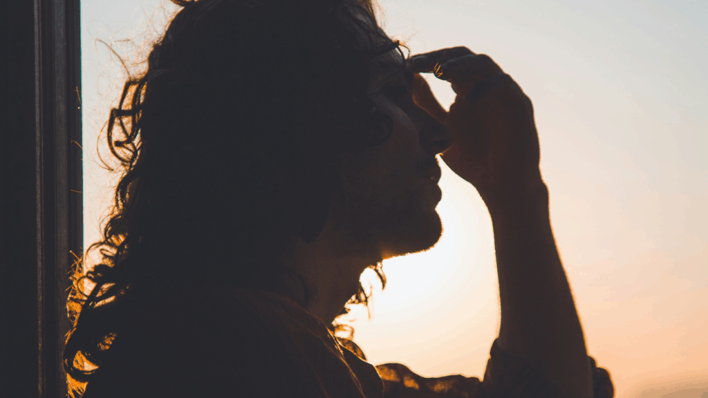 Seitliches Profil einer Frau, die sich gestresst auf den Kopf greift