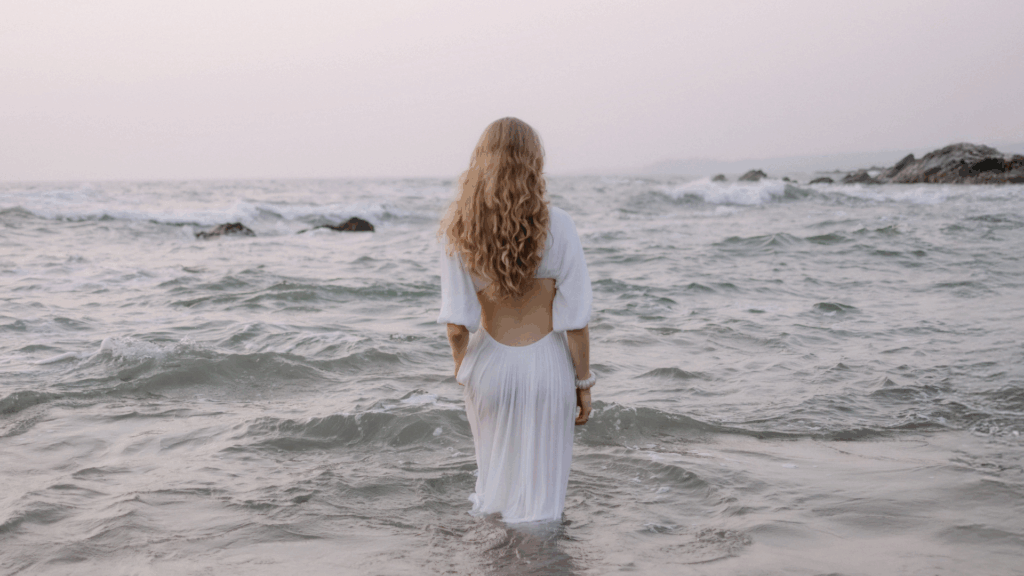 Eine Frau in einem weißen steht im Meer